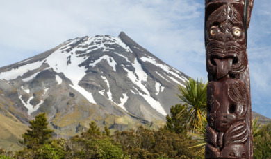 Maori statue in front of Volcano Taranaki, New Zealand